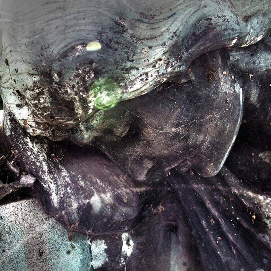 Skulptur einer Frau die traurig nach unten schaut